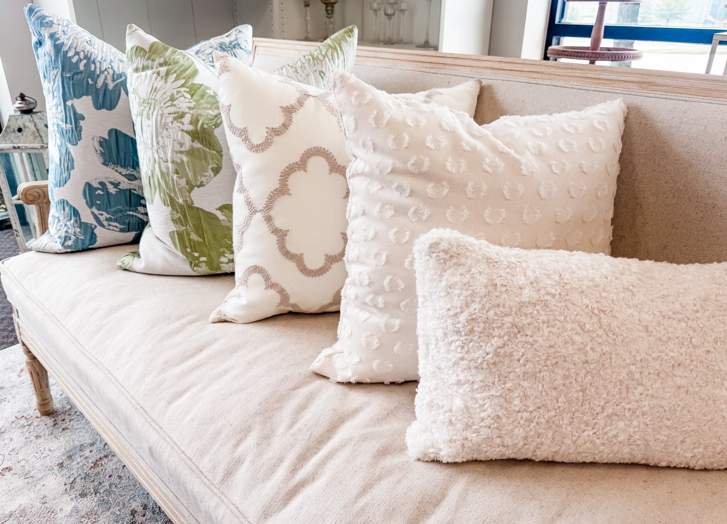 Decorative pillows on a beige sofa in a living room setting