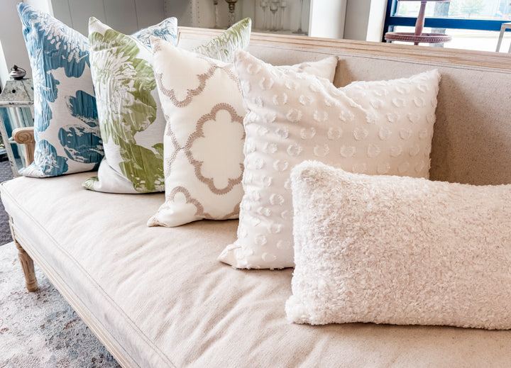 Decorative pillows on a beige sofa in a living room setting